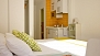 Seville Apartment - The double-bed with kitchenette beyond. There is a fitted-in wardrobe next to the bed.