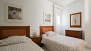 Séville Appartement - The second bedroom has twin beds separated by a bedside table.