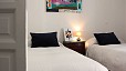 Seville Apartment - The second bedroom features twin beds separated by a bedside table.
