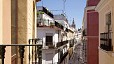 Seville Apartment - Exterior view of Quirós Street. In the background is the Cathedral bell tower - la Giralda.
