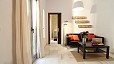 Seville Apartment - Living area with two windows, sofa and central table.