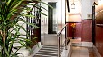 Sevilla Apartamento - Entrada del edificio con un pequeño ascensor al lado de las escaleras.