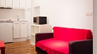 Granada Apartment - Sofa with the kitchenette beyond. On the right is the bathroom entrance.