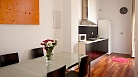Sevilla Apartamento - Mesa comedor con 4 sillas. Al fondo la cocina americana.