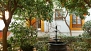 Seville Apartment - Courtyard with orange trees and a central fountain.