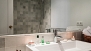 Séville Appartement - Marble-tiled bathroom with bathtub.