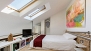 Grenade Appartement - The sleeping area has wooden flooring and velux windows.