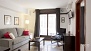 Sevilla Apartamento - The living room is brightly lit by a large window.