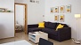 Séville Appartement - Living room with sofa. The door opens to the bedroom (lower floor).
