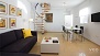 Seville Apartment - General view of the living-dining room. Spiral stairs lead to the second floor.