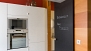 Seville Apartment - Kichen. Appliances include an oven and microwave. The door on the right opens to an additional toilet.