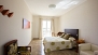 Séville Appartement - Bedroom 1 with double bed (150x200cm), desk, wardrobe and en-suite bathroom.
