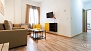 Seville Apartment - Living room with sofa, coffee table, armchair and TV.