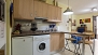 Séville Appartement - Kitchen includes a Nespresso coffee machine, washing machine, fridge, microwave and stove.