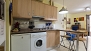 Sevilla Ferienwohnung - Kitchen includes a Nespresso coffee machine, washing machine, fridge, microwave and stove.