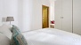 Sevilla Apartamento - The bedroom has a large wardrobe. The door opens to the bathroom.