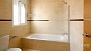 Seville Apartment - En-suite bathroom with a tub and over-head shower.