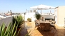 Seville Apartment - Lower terrace furnished and decorated with plants, table, chairs and parasol.