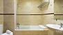 Seville Apartment - Bathroom 1 with bathtub and an overhead shower.