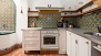 Séville Appartement - The kitchen has antique tiles as well as modern appliances.