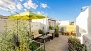 Seville Apartment - Terrace No.1 (shared). It is equipped and decorated with plants, parasol and lounge sofas.