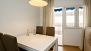 Séville Appartement - Dining table with 4 chairs. The door opens to a balcony.